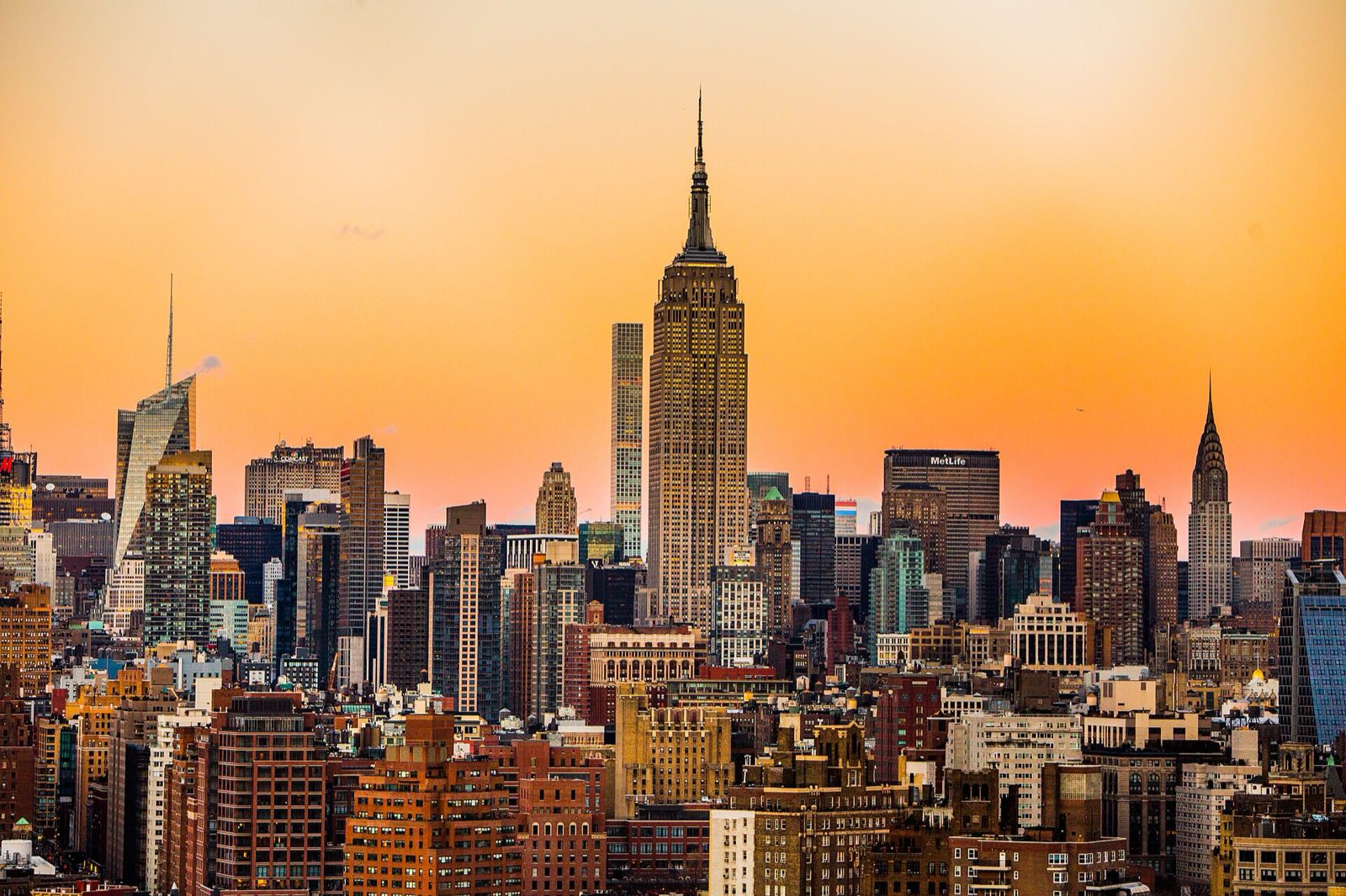 The Empire State Building above the Manhattan skyline at sunset.
