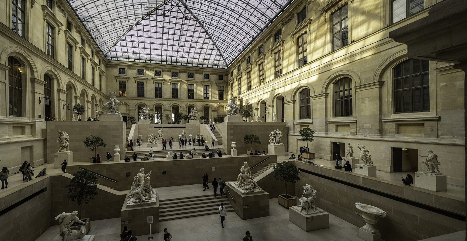 The Cour Marly in the Louvre, a glass-roofed courtyard filled with French sculpture.