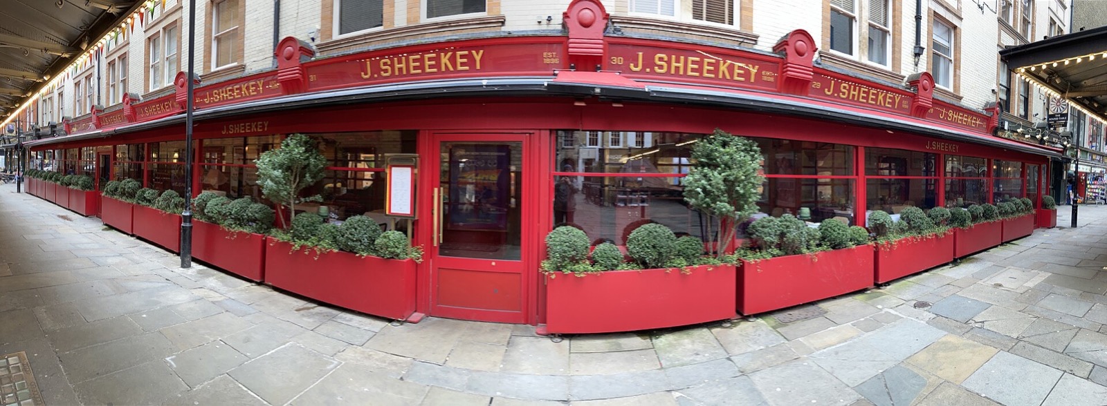 The red front of J Sheekey along the length of St Martin's Court.