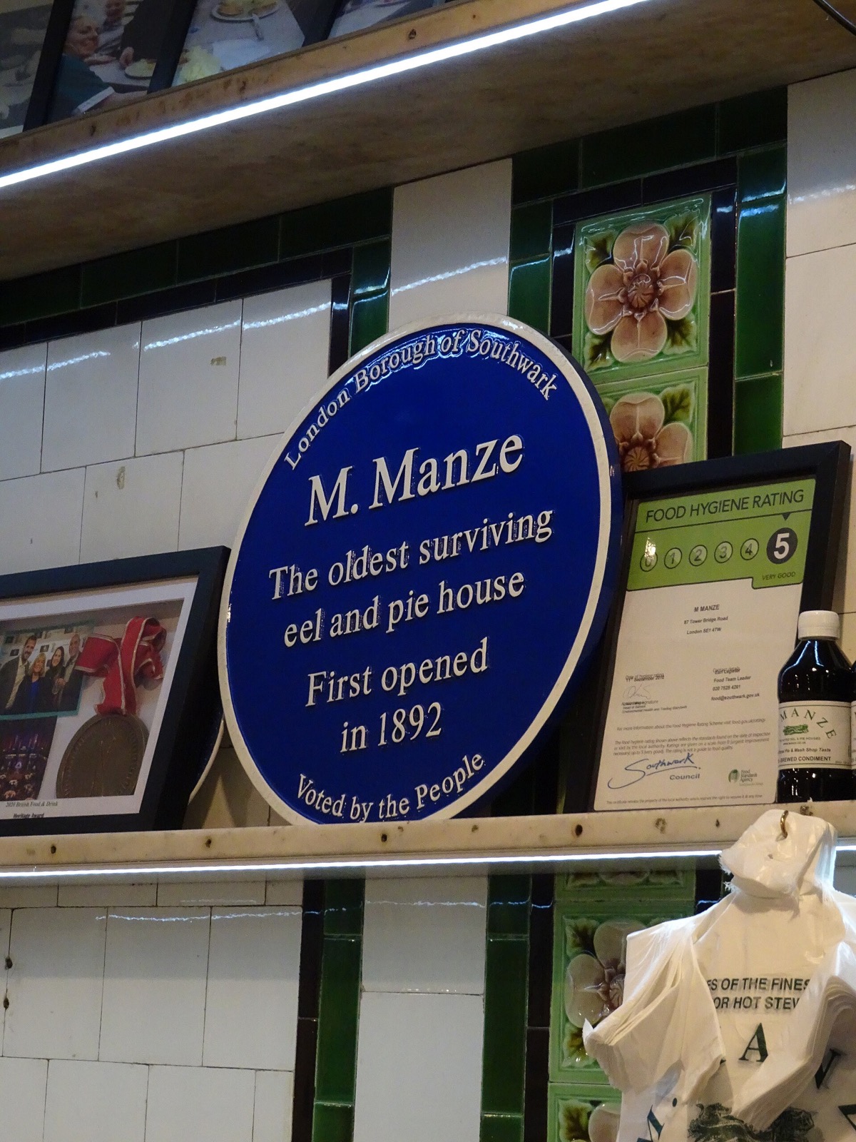 The blue plaque inside M.Manze: the oldest surviving eel and pie house, first opened in 1892.
