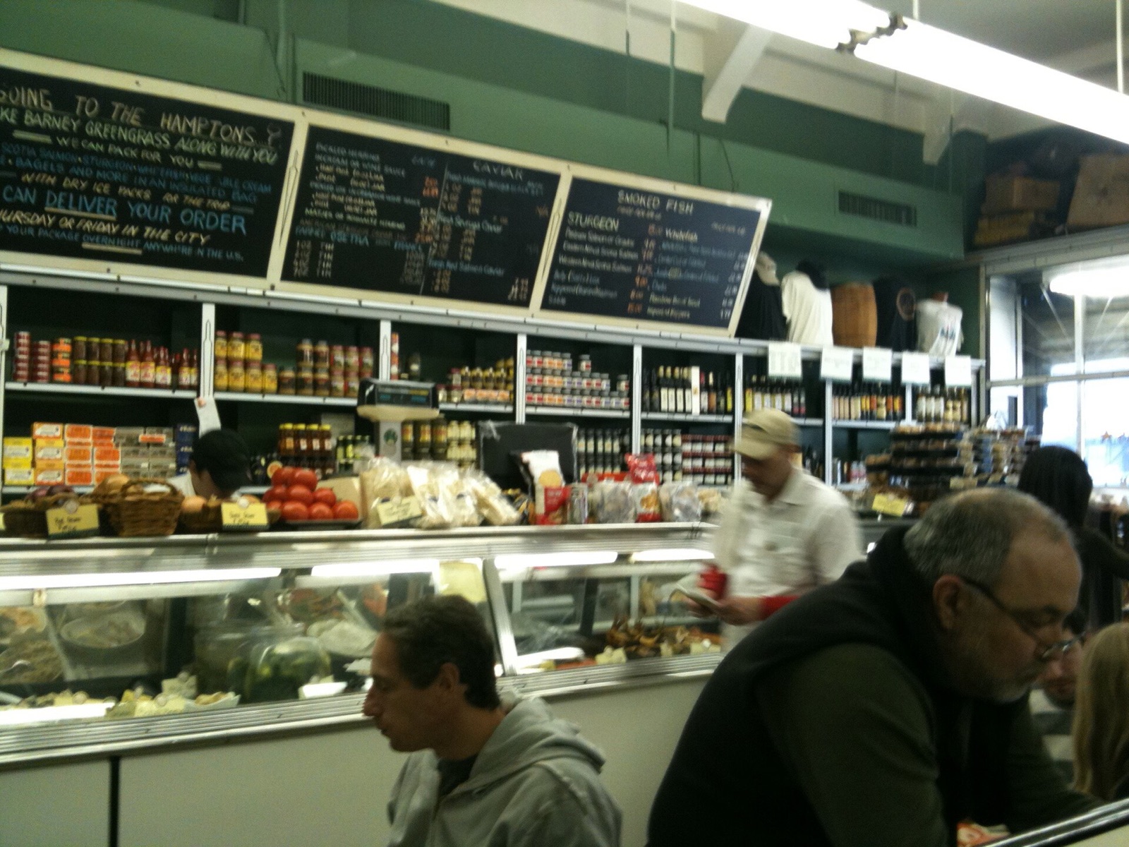 The counter at Barney Greengrass, with customers at the tables in front of it.