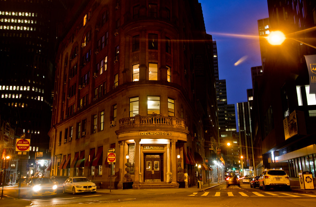 Delmonico's lit at night, on the corner of Beaver and William Streets.