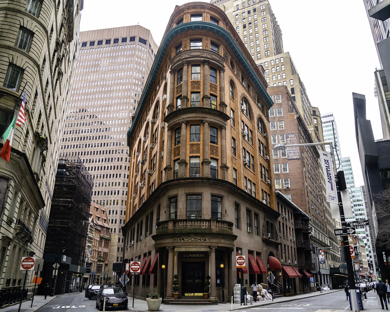 Delmonico's at the point of a triangular block in the Financial District, with columns at its corner door.