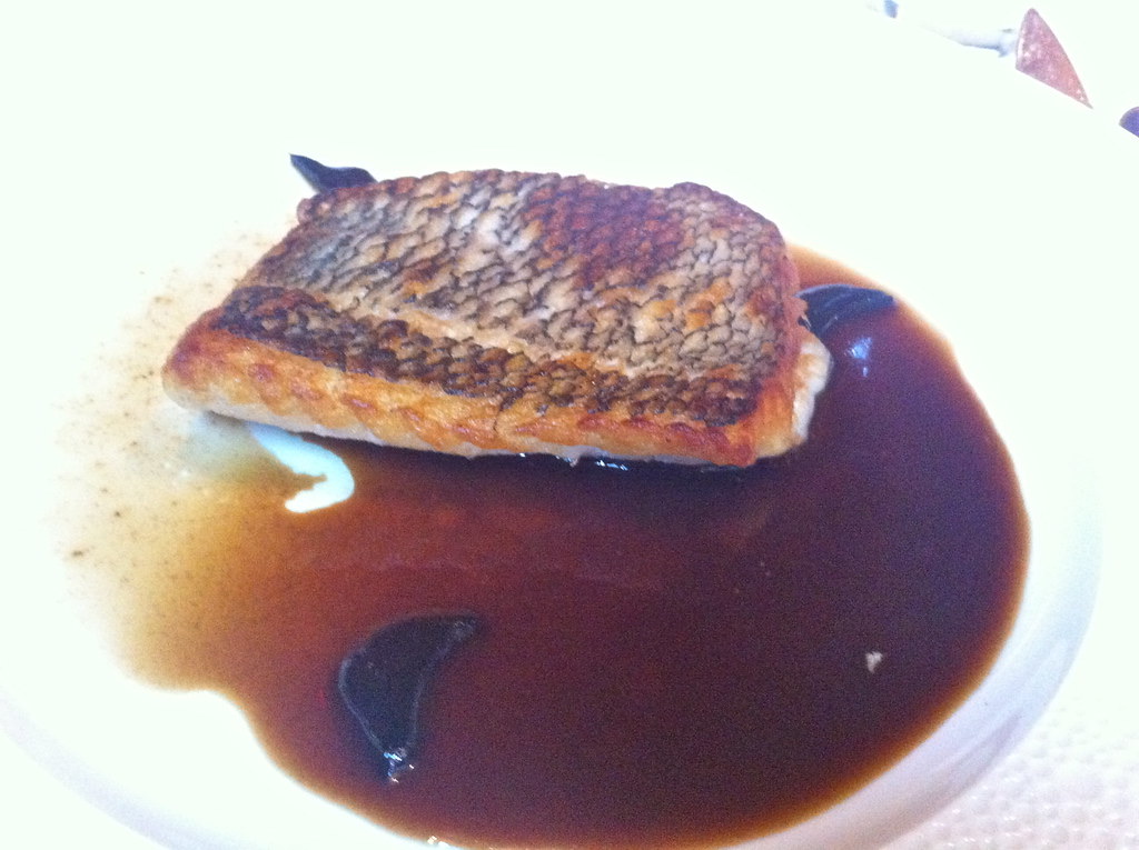 A plate of crisp black bass in a dark sauce at Le Bernardin.