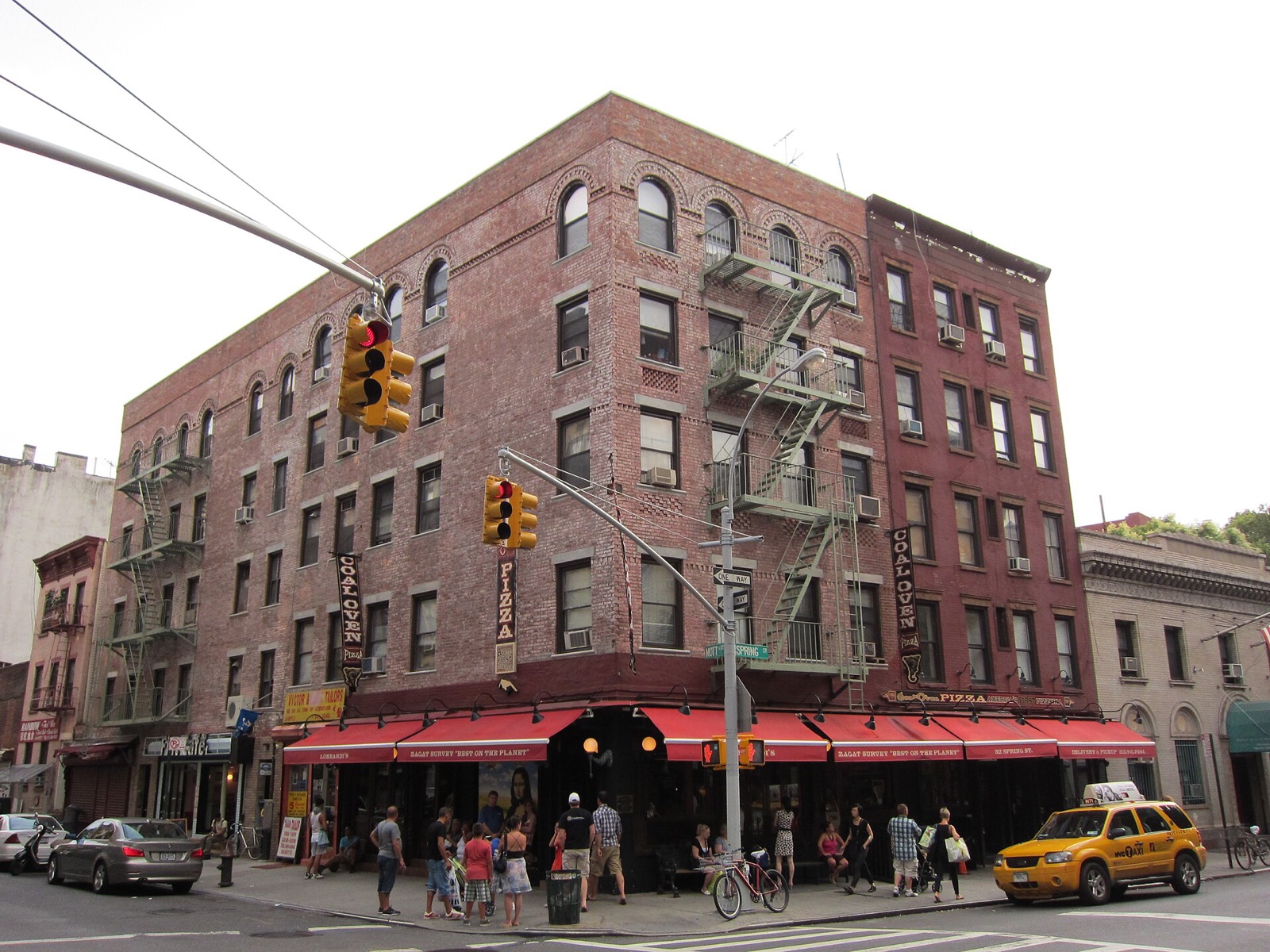 The brick building at the corner of Spring and Mott Streets with Lombardi's on its ground floor.
