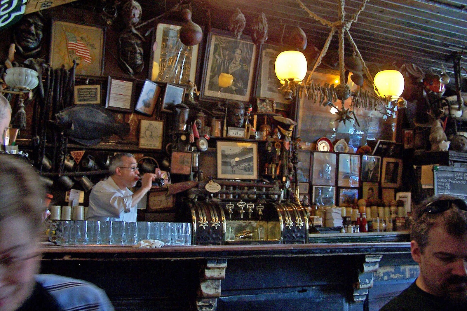The bar at McSorley's, every inch of wall behind it covered in old pictures and clutter.