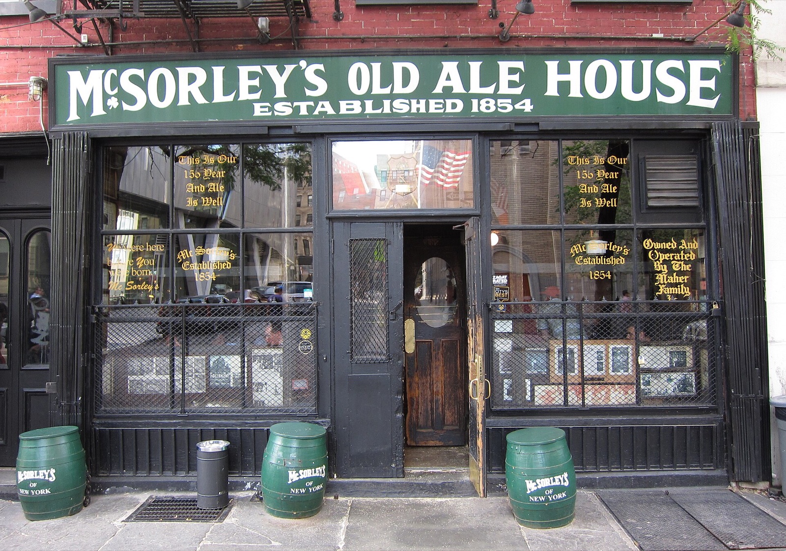 The front of McSorley's Old Ale House on East 7th Street, with its green sign and barrels at the door.