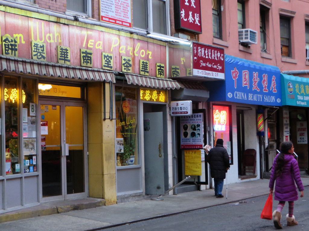The front of the Nom Wah Tea Parlor on Doyers Street, under its red and yellow sign.