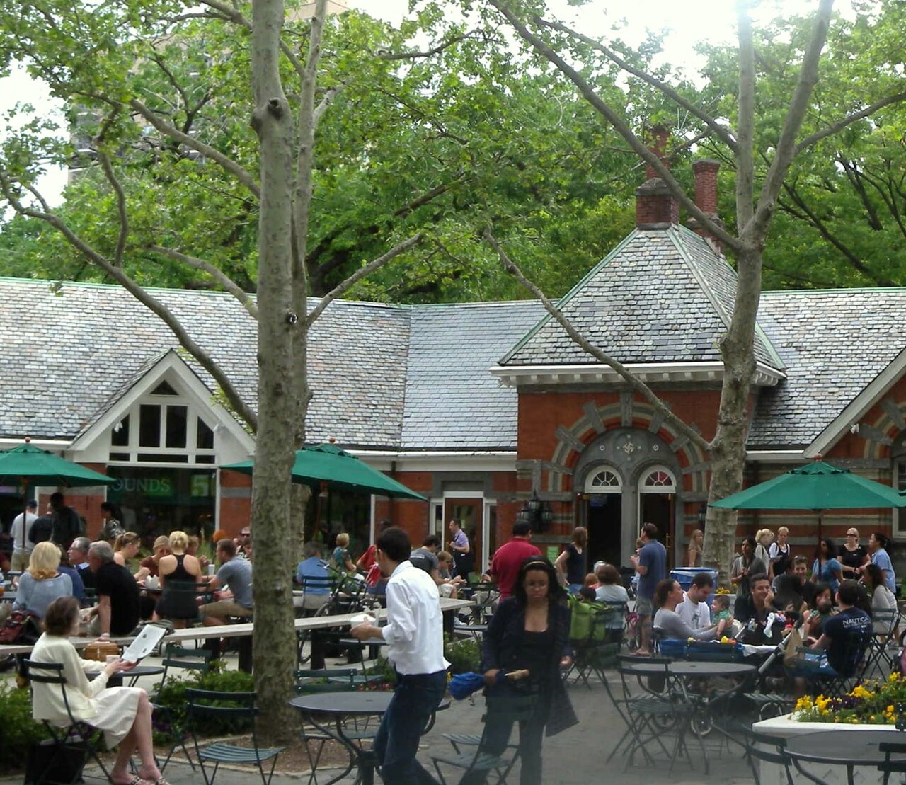 Tables in the courtyard of Tavern on the Green in spring, under the trees.