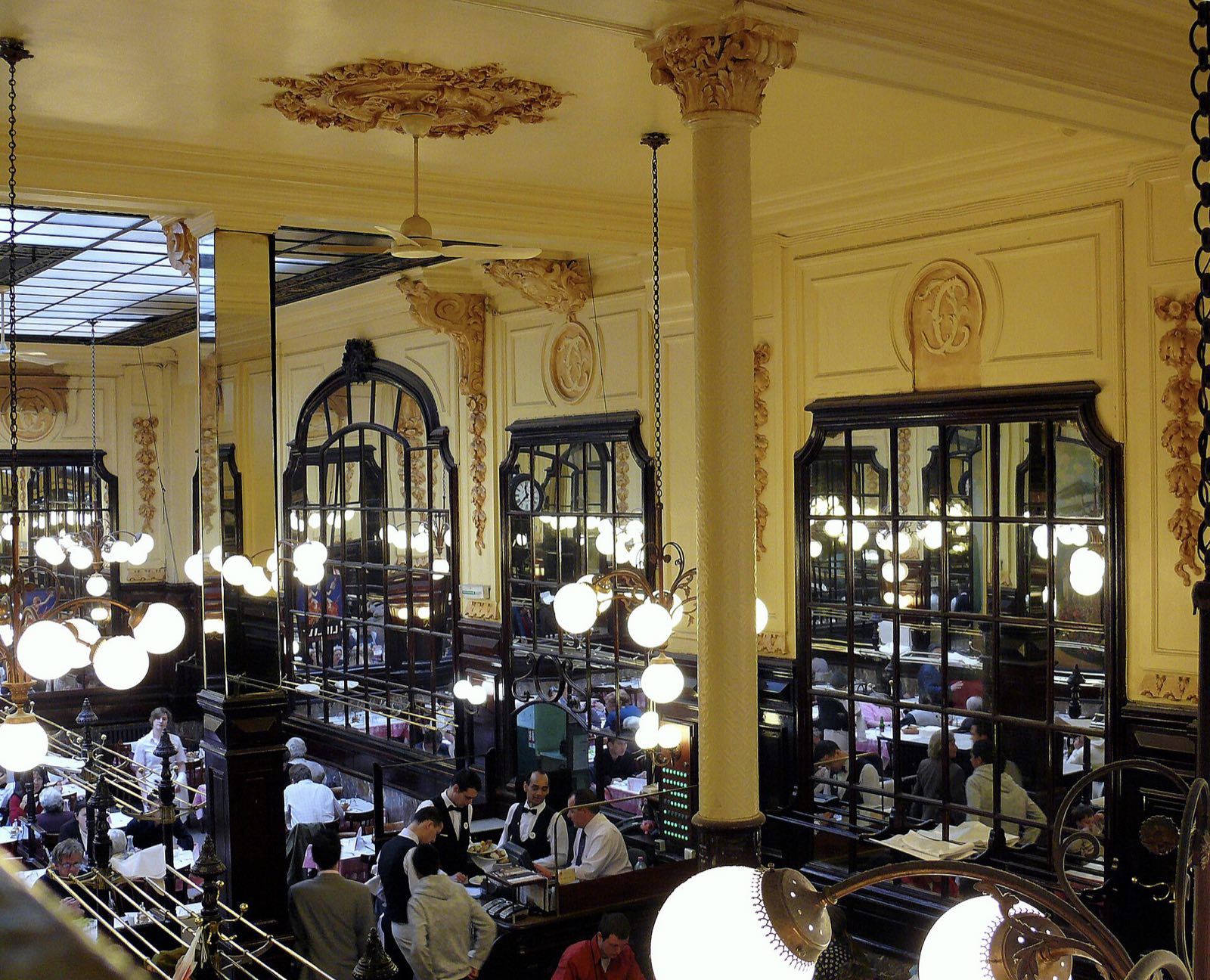 The dining hall of Bouillon Chartier, with its mezzanine, globe lamps and tables laid close together.