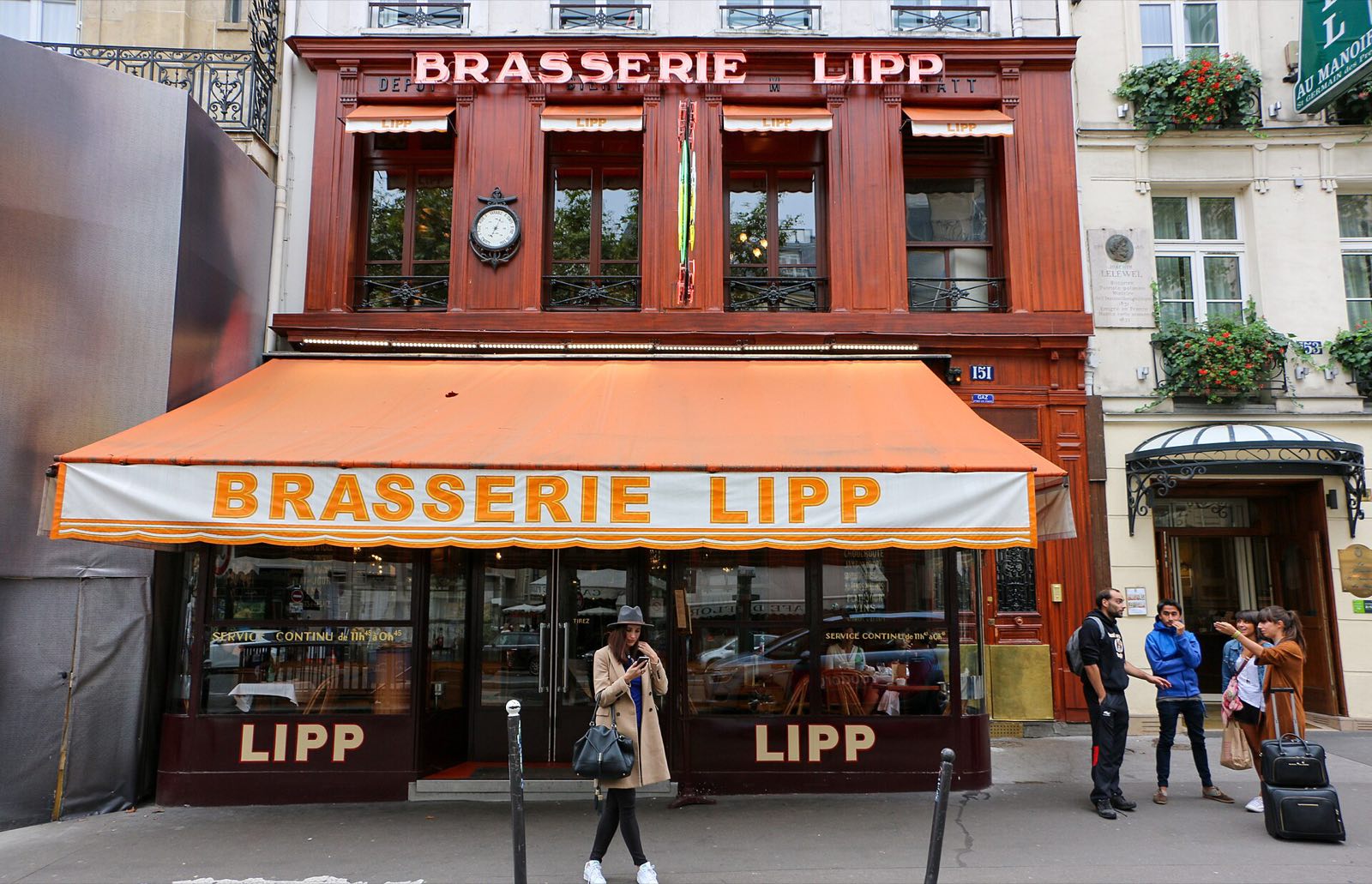 The front of Brasserie Lipp on the boulevard Saint-Germain, wood panelling and an orange awning.