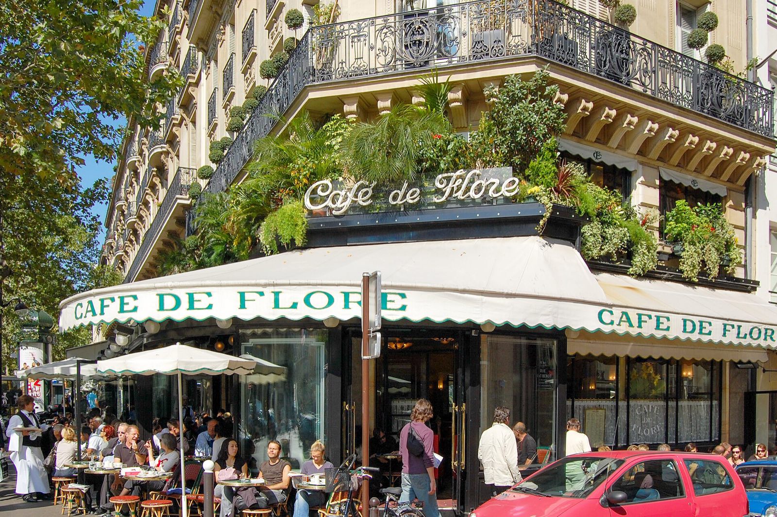 The Café de Flore on the boulevard Saint-Germain, its terrace under a white awning and a balcony of plants.