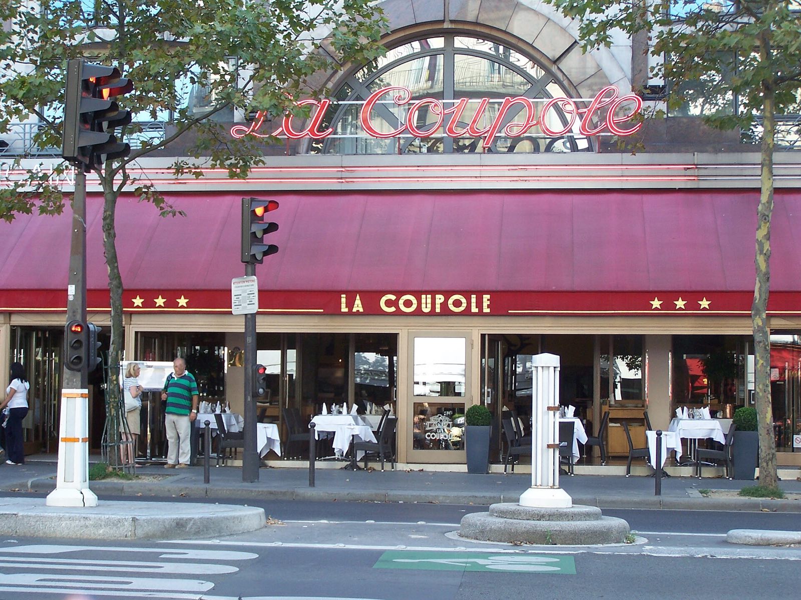 The front of La Coupole on the boulevard du Montparnasse, under a red awning.
