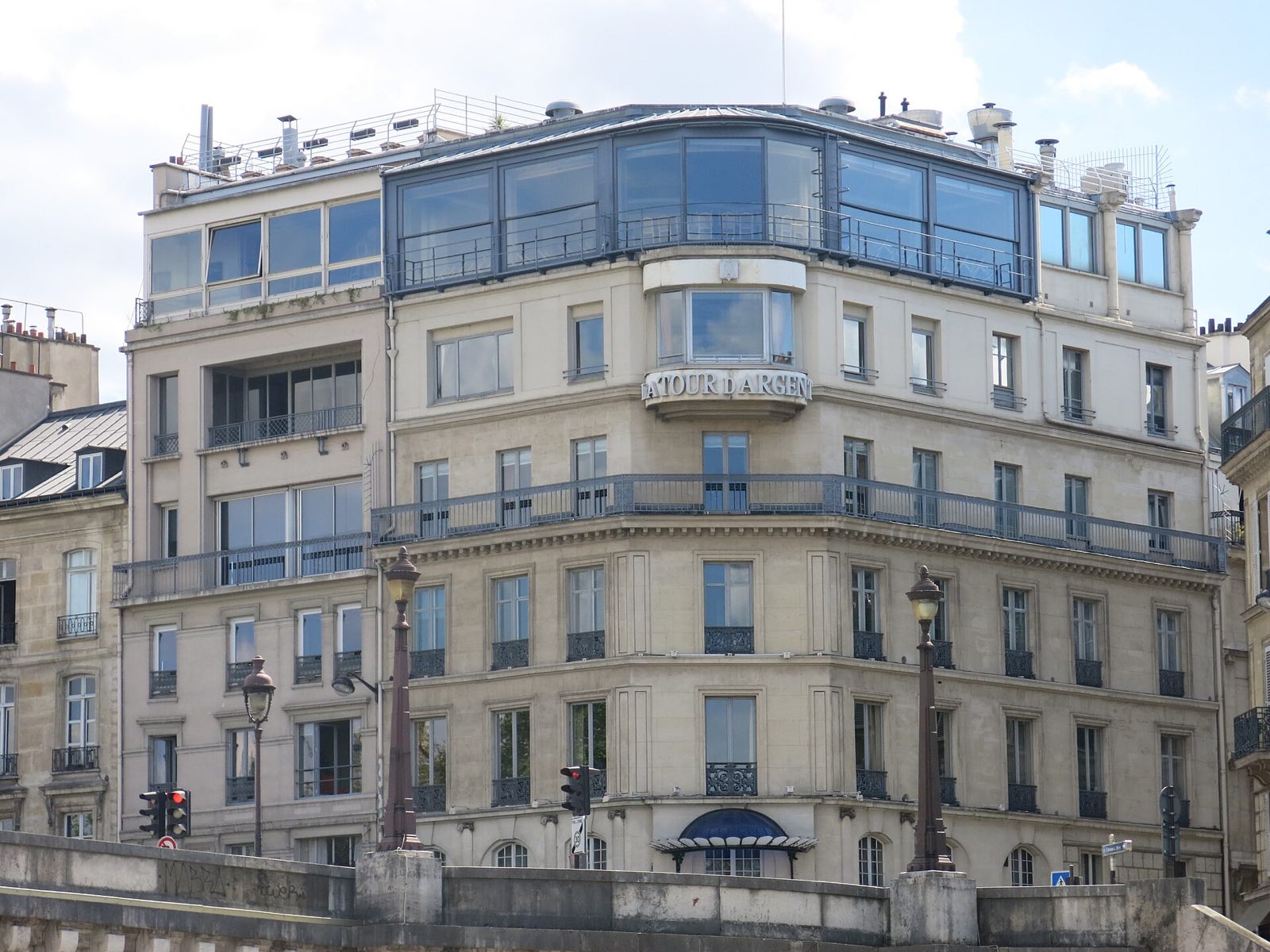 The building of La Tour d'Argent seen from the Seine, the glass dining room on its top floor.