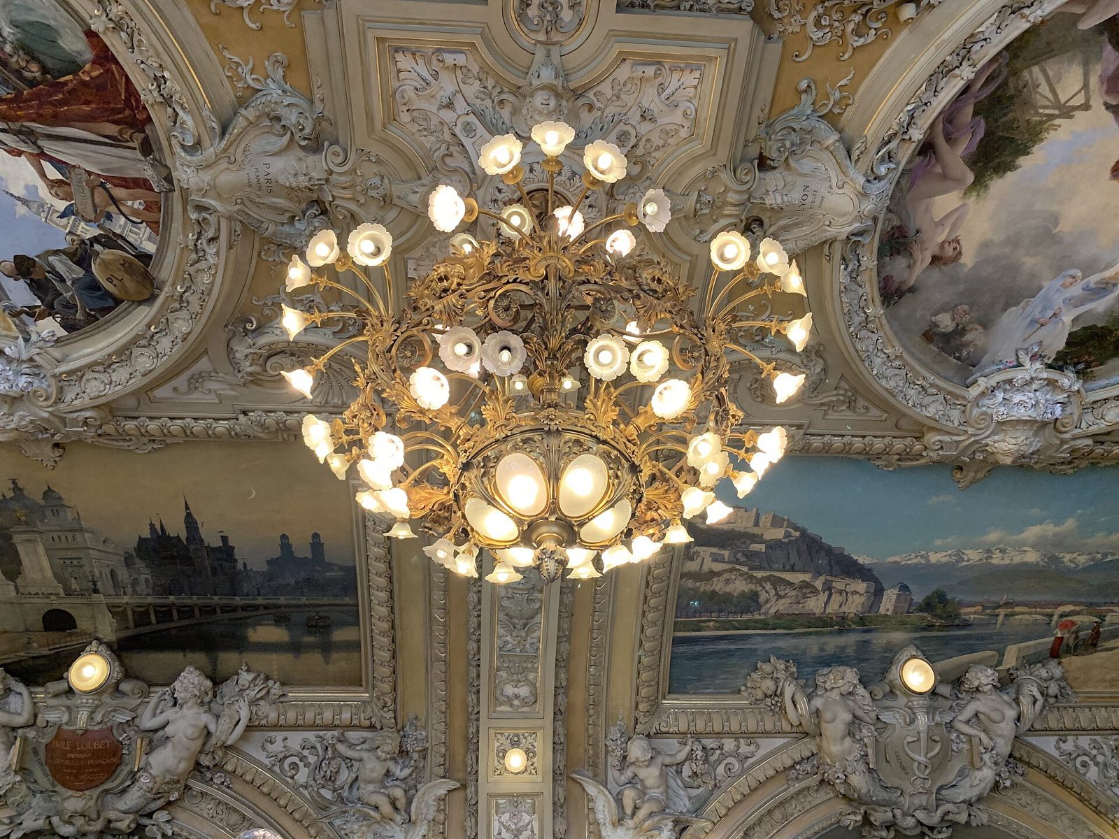 A chandelier under the painted and gilded ceiling of Le Train Bleu.