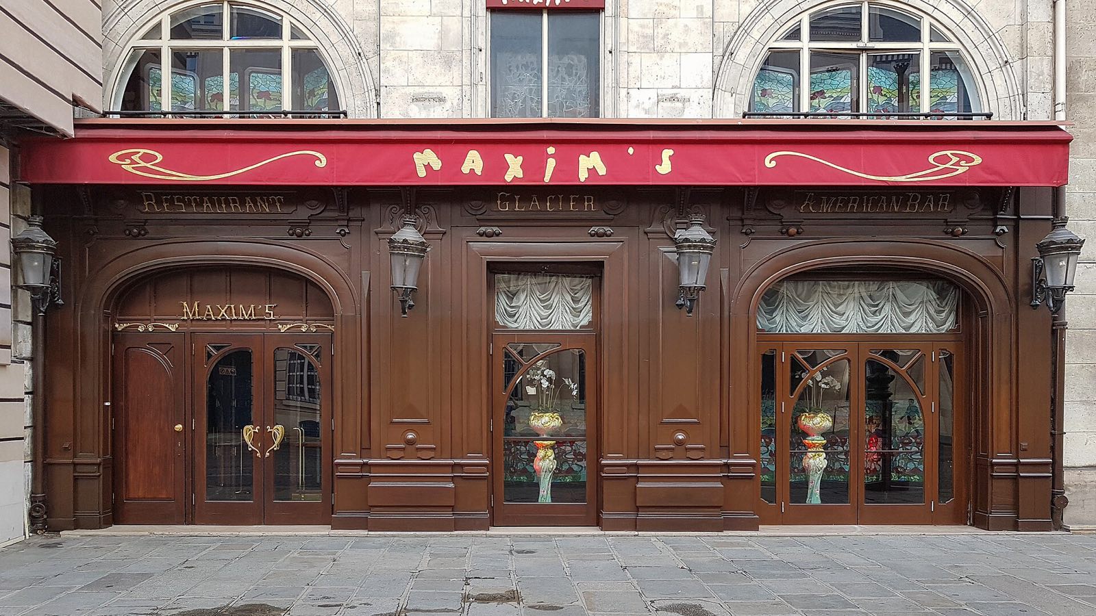 The dark wood front of Maxim's on the rue Royale, under a red awning.