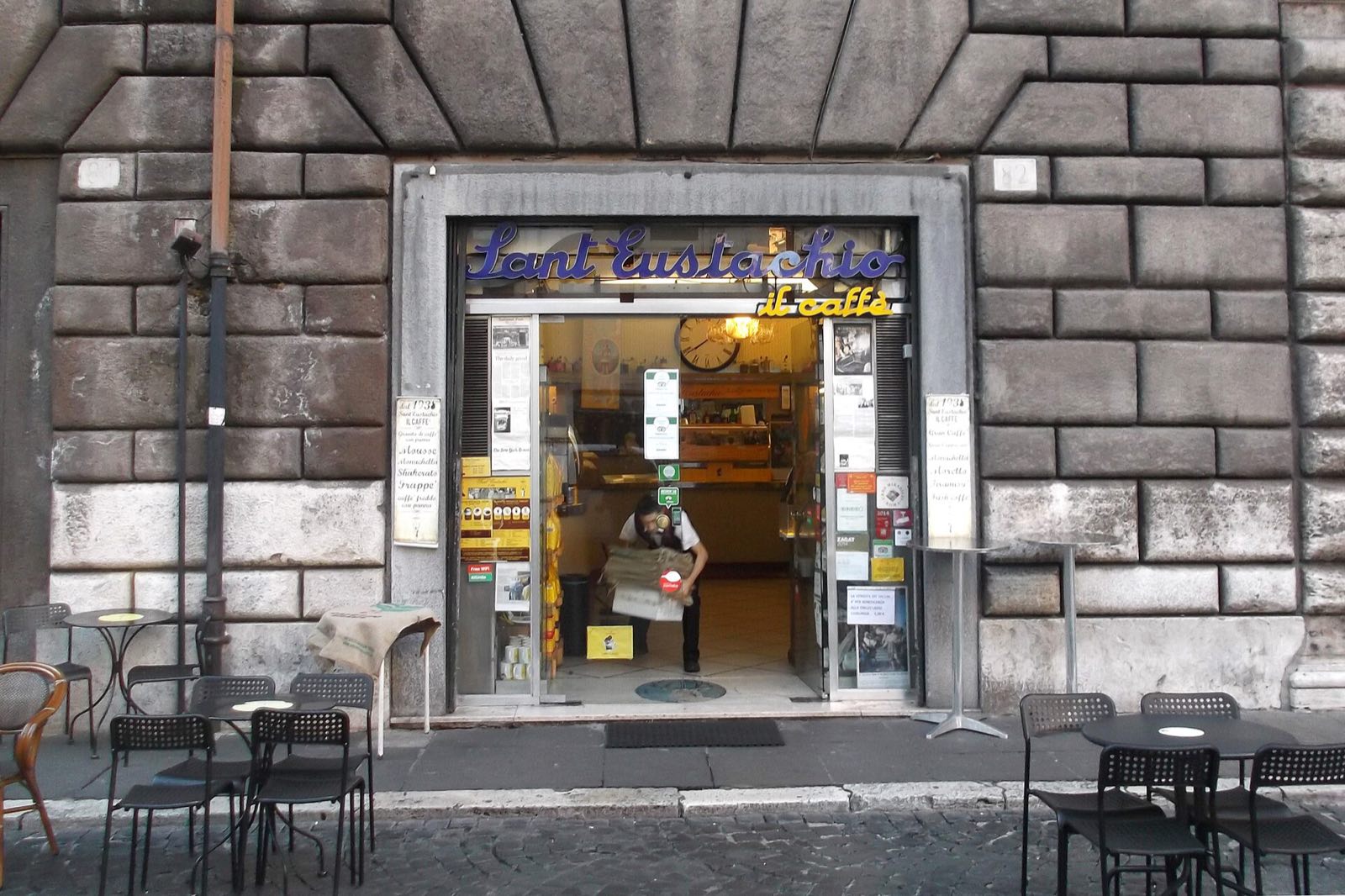 The front of Sant'Eustachio Il Caffè, with its sign over the door and tables on the square.