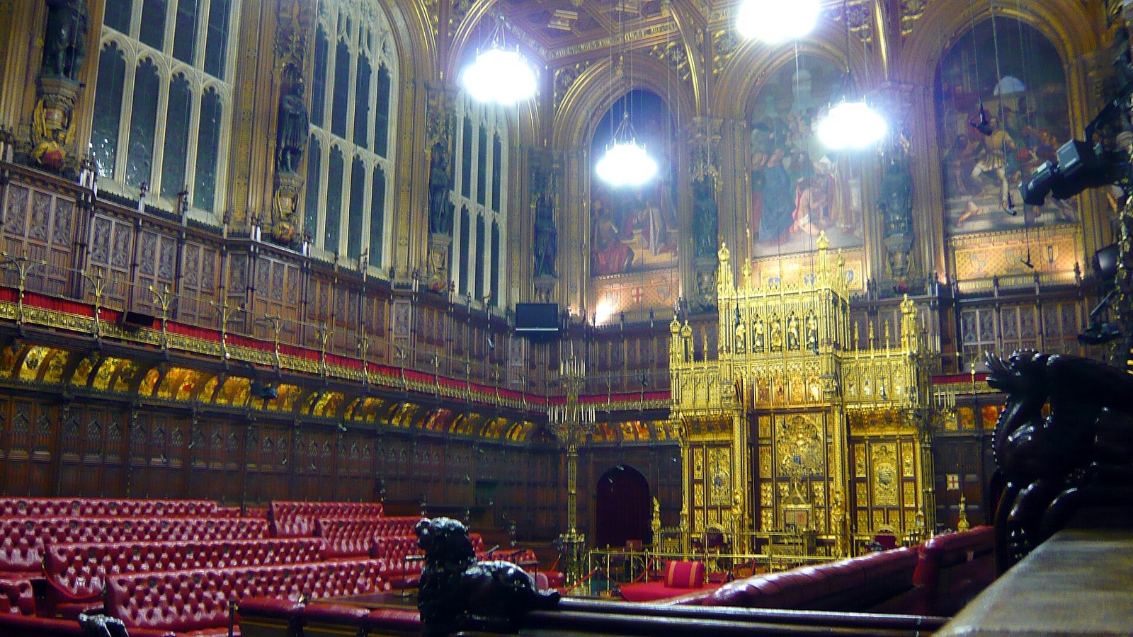 The chamber of the House of Lords, red leather benches before the gilded throne.