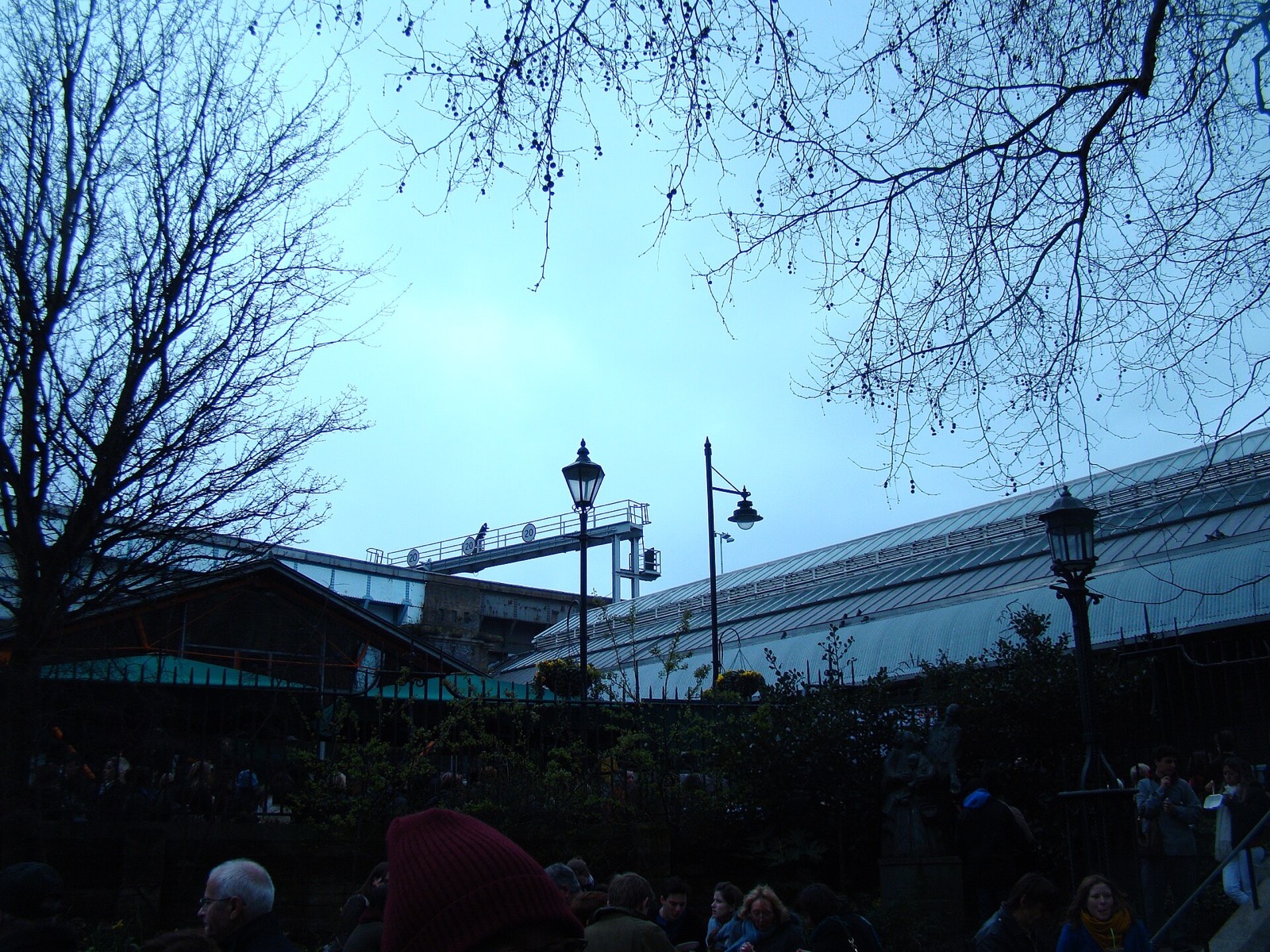 The glass roofs of Borough Market under the railway viaduct at dusk.
