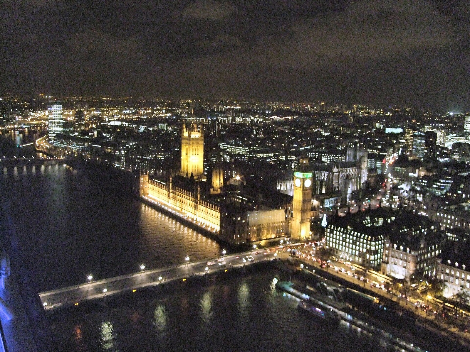 The Houses of Parliament and Big Ben lit at night, seen from a capsule of the London Eye.