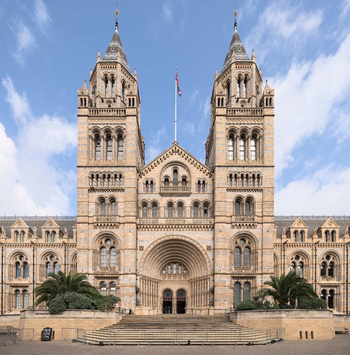 The front of the Natural History Museum, a Romanesque cathedral of buff and blue terracotta with twin towers.