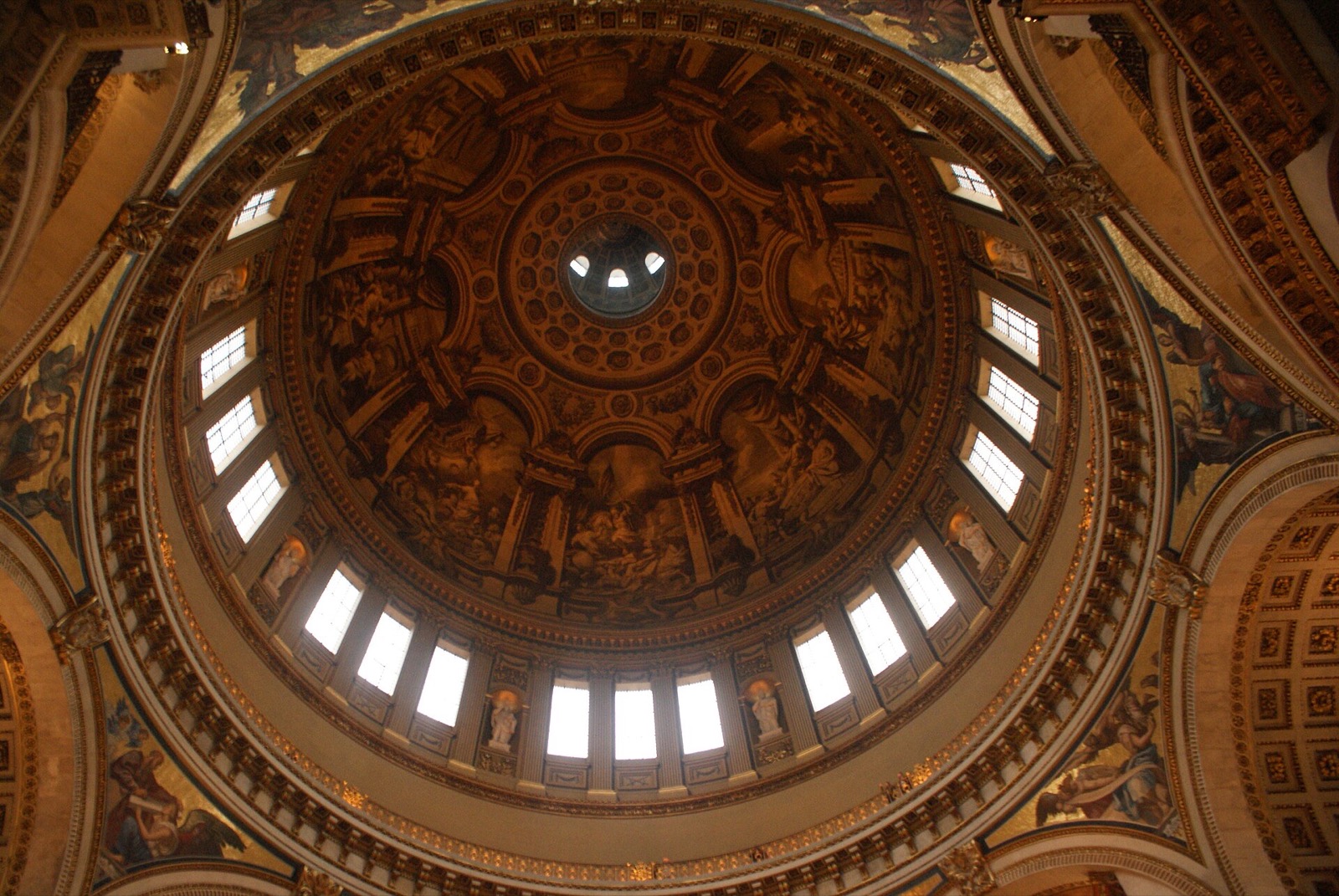 Looking straight up into the painted dome of St Paul's Cathedral, ringed with windows.