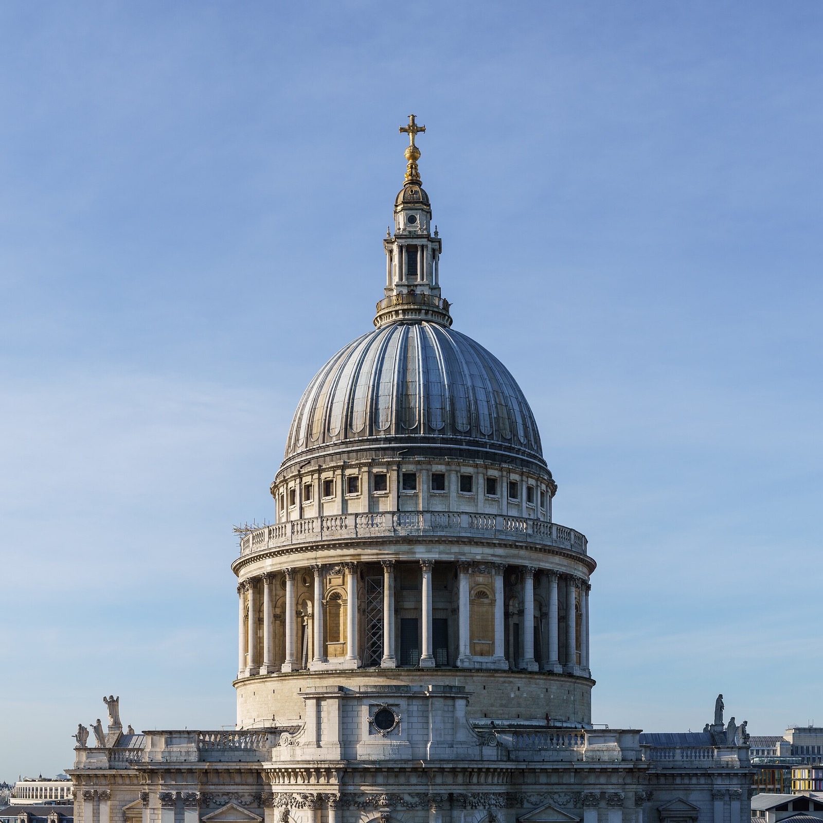 The dome of St Paul's Cathedral, lead-covered above a ring of columns, seen from a rooftop to the east.