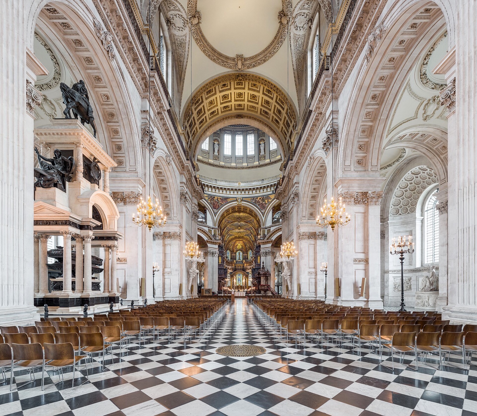The nave of St Paul's Cathedral, a chequered marble floor leading under round arches to the dome.