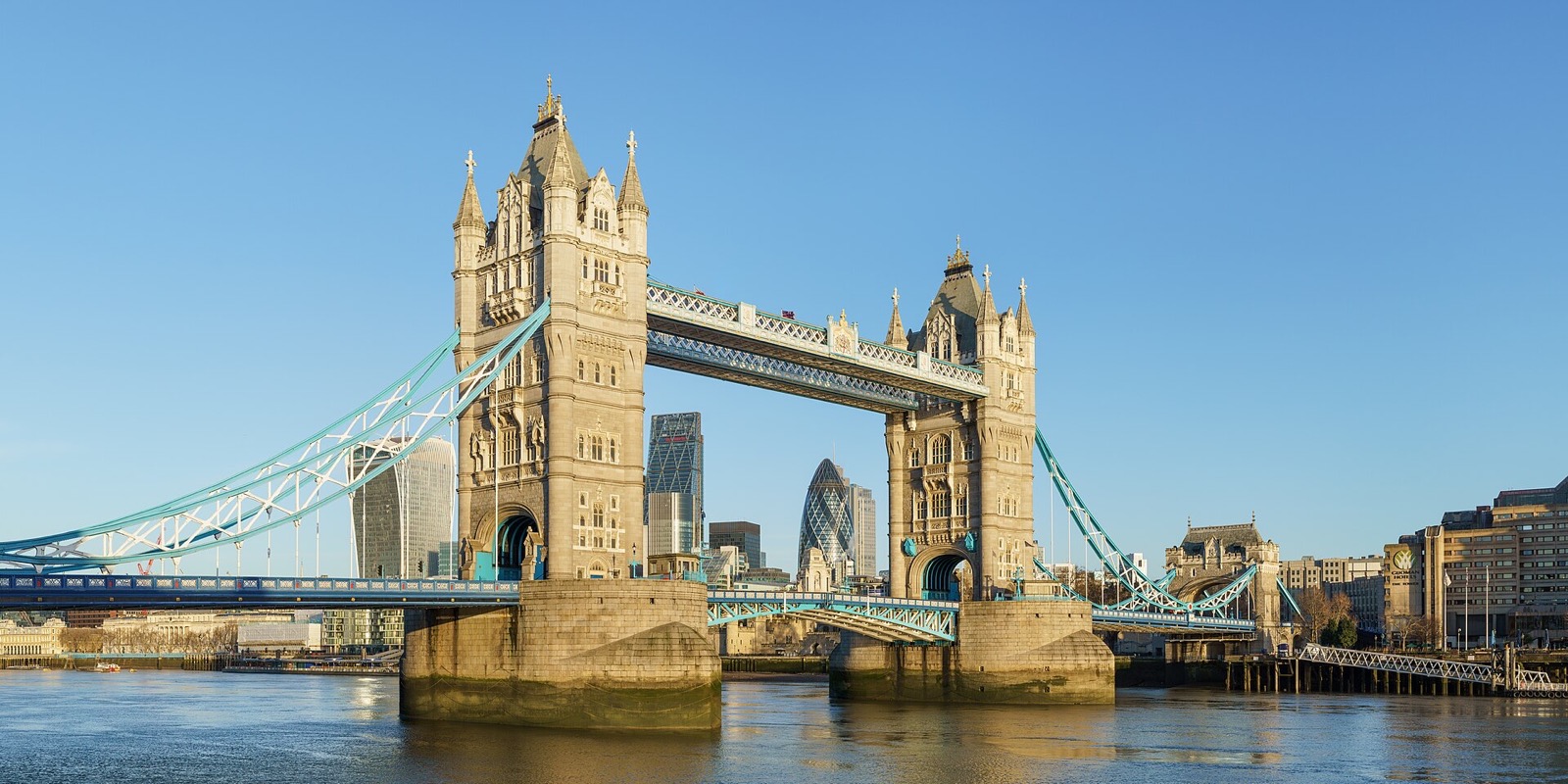 Tower Bridge seen from the south bank: two stone towers joined by high walkways, with the road between them.