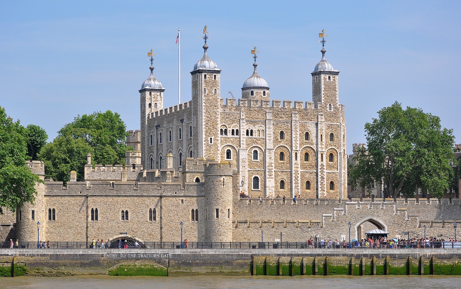 The Tower of London seen from the Thames, the White Tower rising behind the outer walls.
