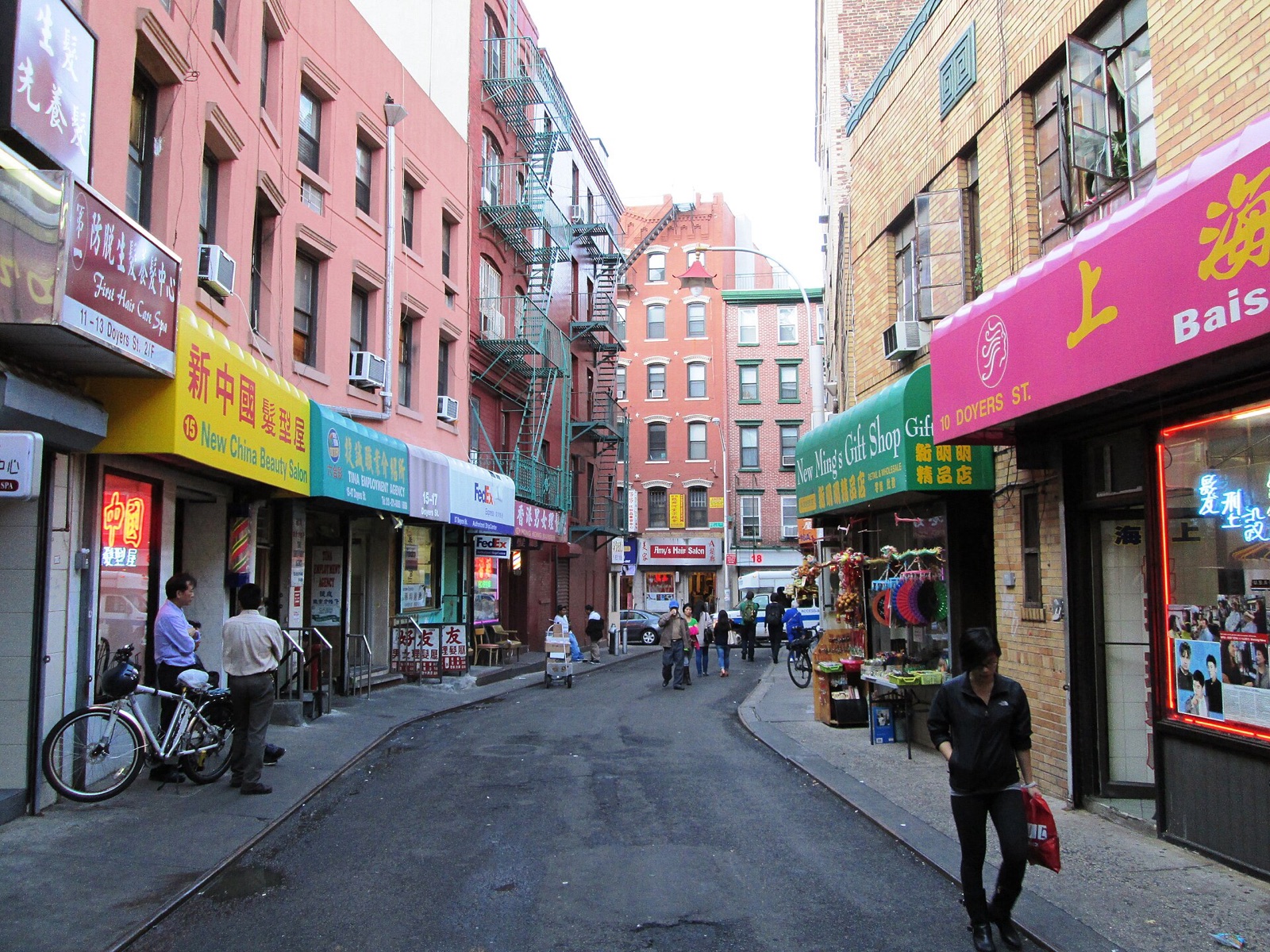 The bend of Doyers Street in Chinatown, lined with shop signs in Chinese.
