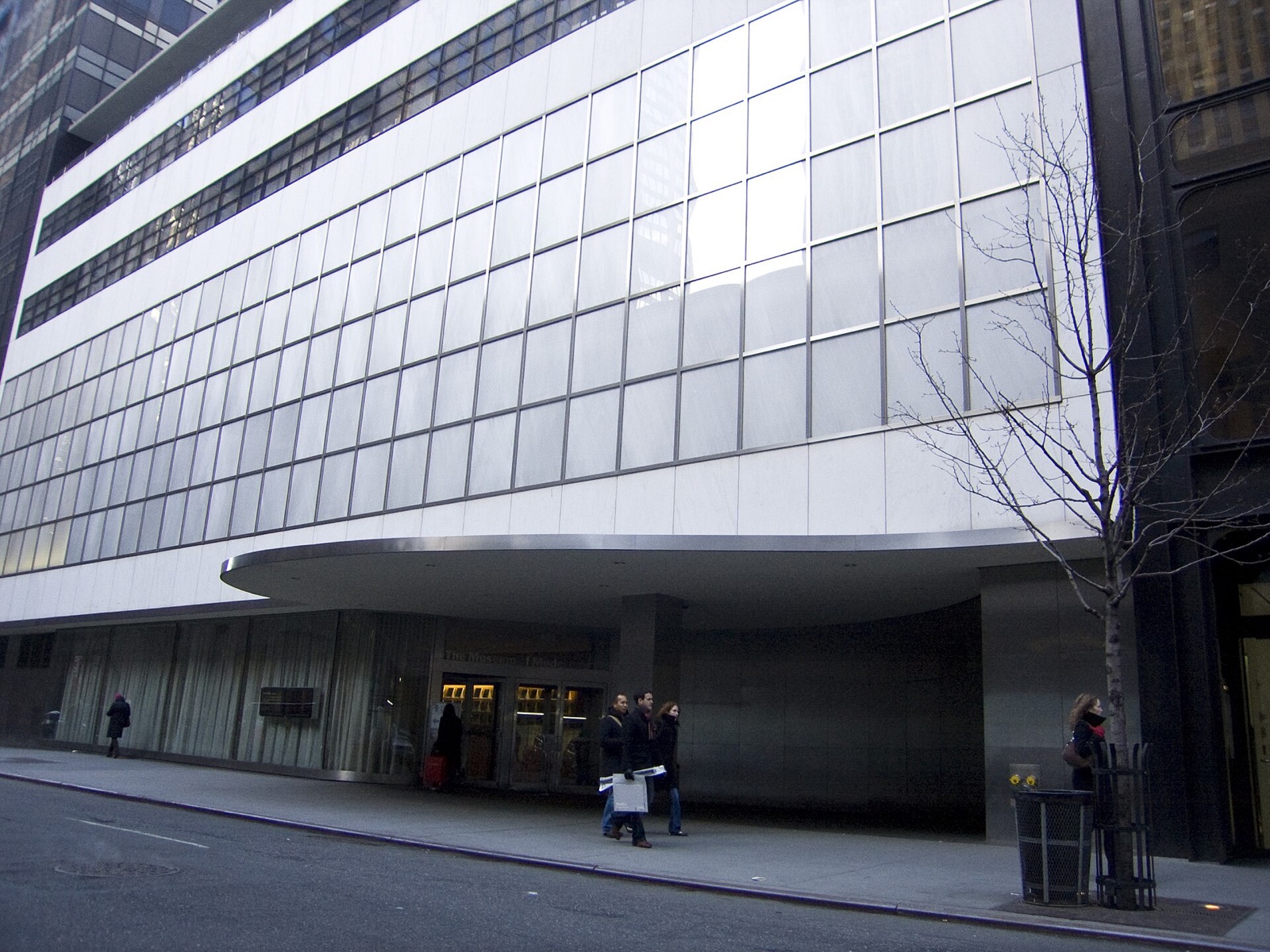 The Museum of Modern Art on West 53rd Street, its glass and steel front under a white canopy.