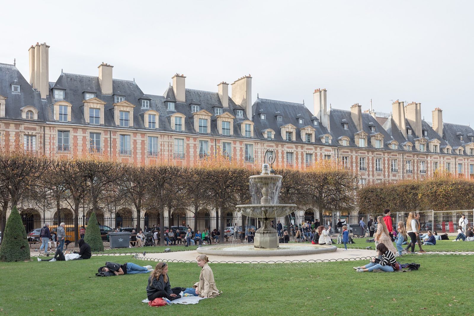 The Place des Vosges in Le Marais, houses of red brick and stone over arcades around a garden.
