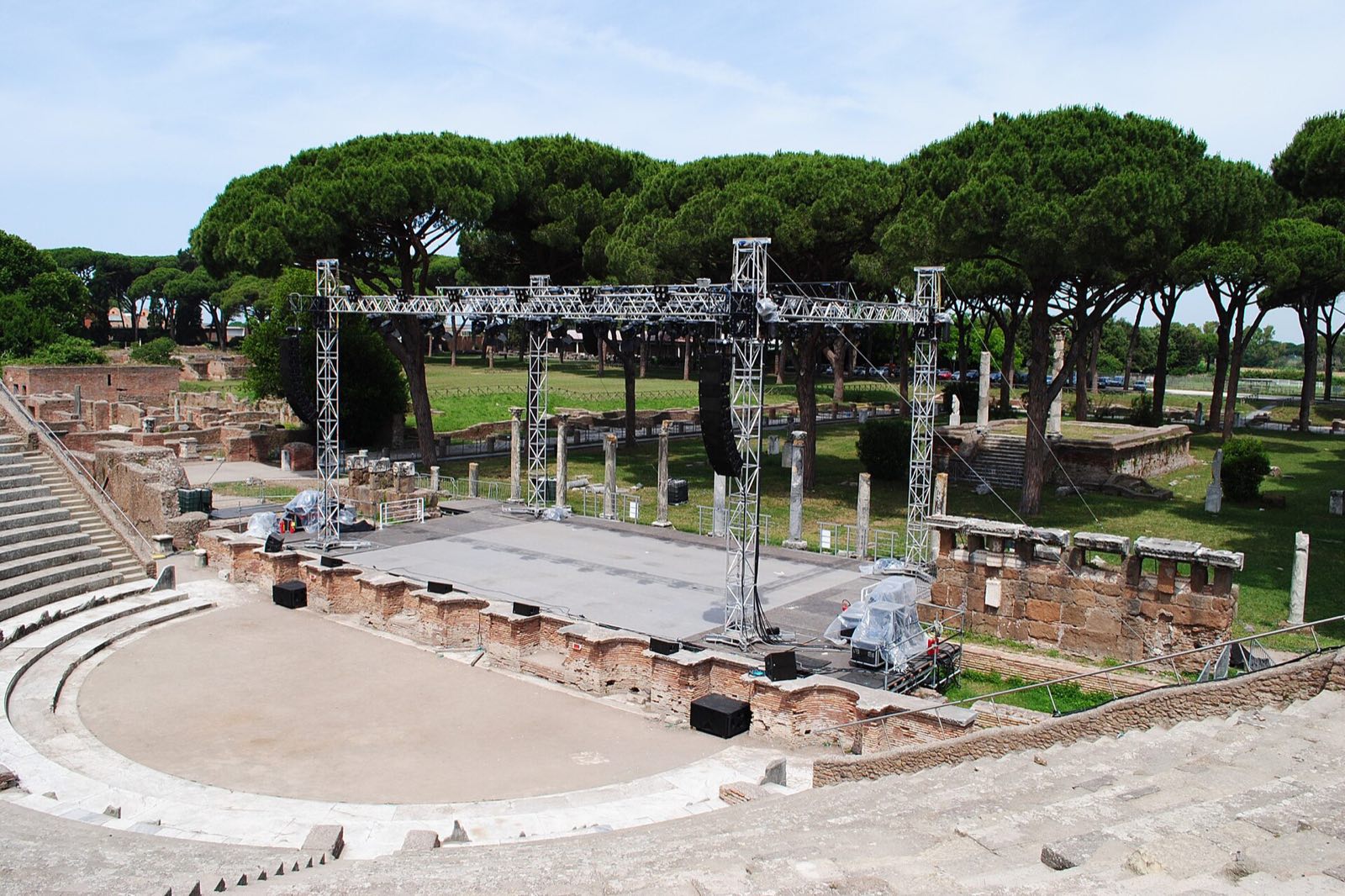 Brick ruins and the theatre of Ostia Antica among umbrella pines.