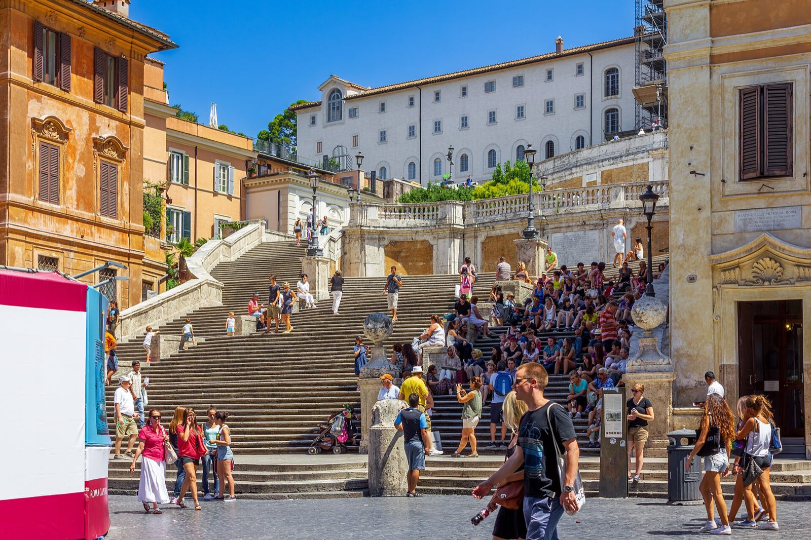 The Spanish Steps crowded with people, climbing to the twin towers of Trinità dei Monti.